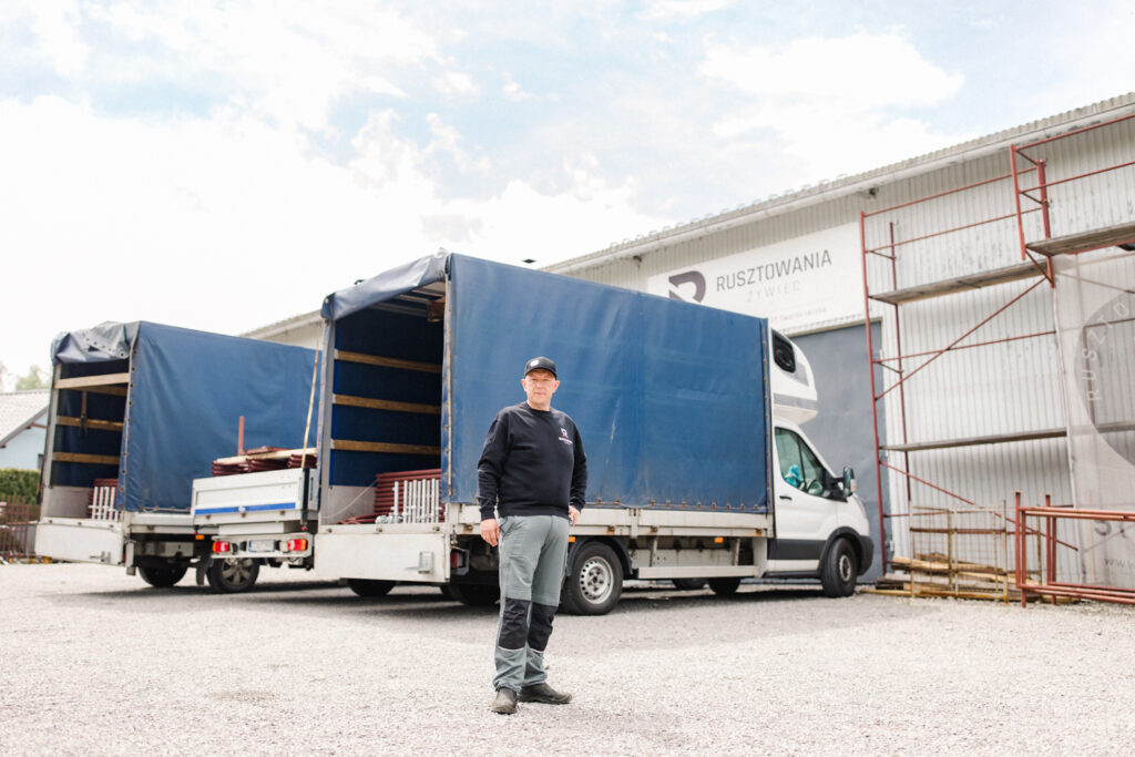 Rafał Adamczyk przed zakładem Rusztowania Żywiec i załadowanym transportem rusztowania elewacyjnego 250 m2